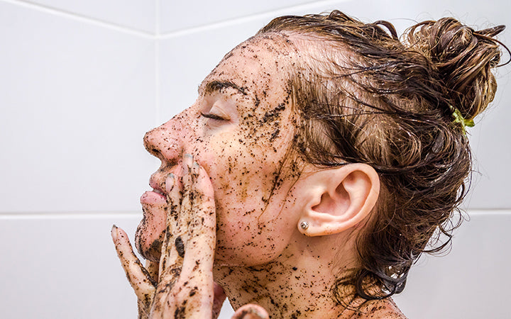 gezicht van een jong meisje op zwarte koffie is gedeponeerd masker dat een bad neemt