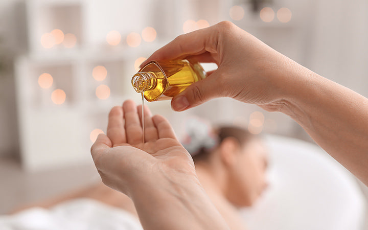 Massagetherapeut giet etherische olie op de hand