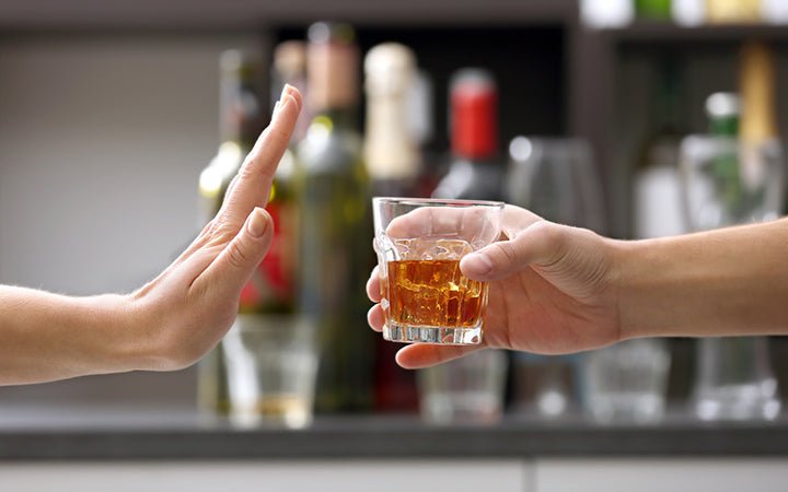 Vrouwelijke hand afwijzend glas met alcoholische drank