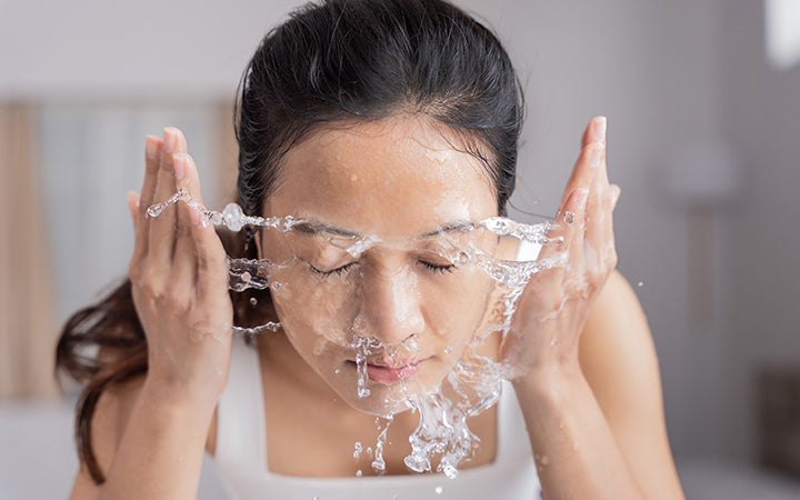 Vrouw die haar gezicht wast