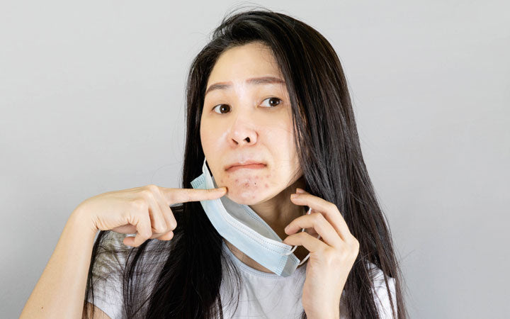 jonge Aziatische vrouw die medisch gezichtsmasker draagt