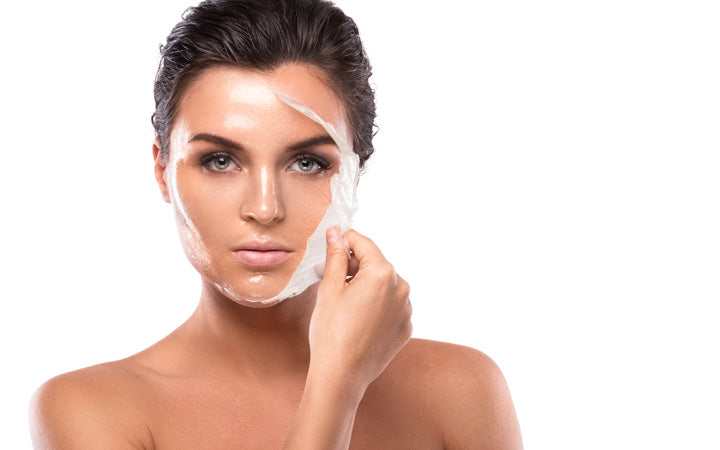Vrouw die moisturizer op gezicht aanbrengt