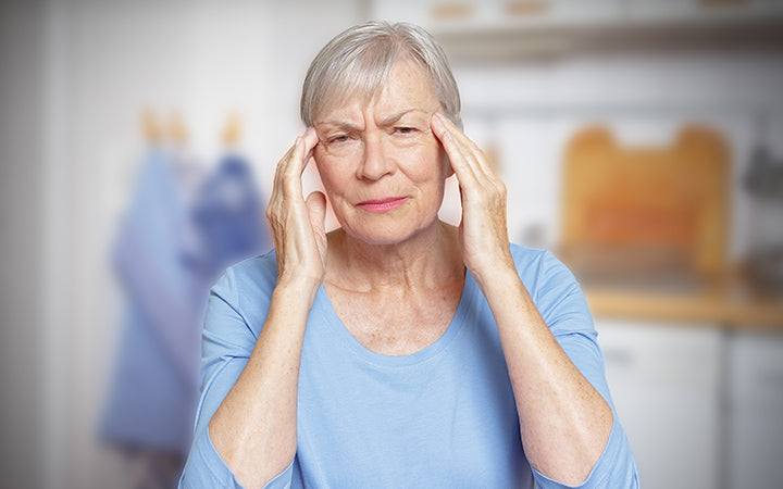 Oudere vrouw die lijdt aan acute hoofdpijn
