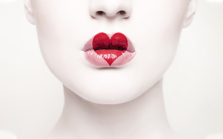 mooi jong meisje met een hart geschilderd op zijn lippen
